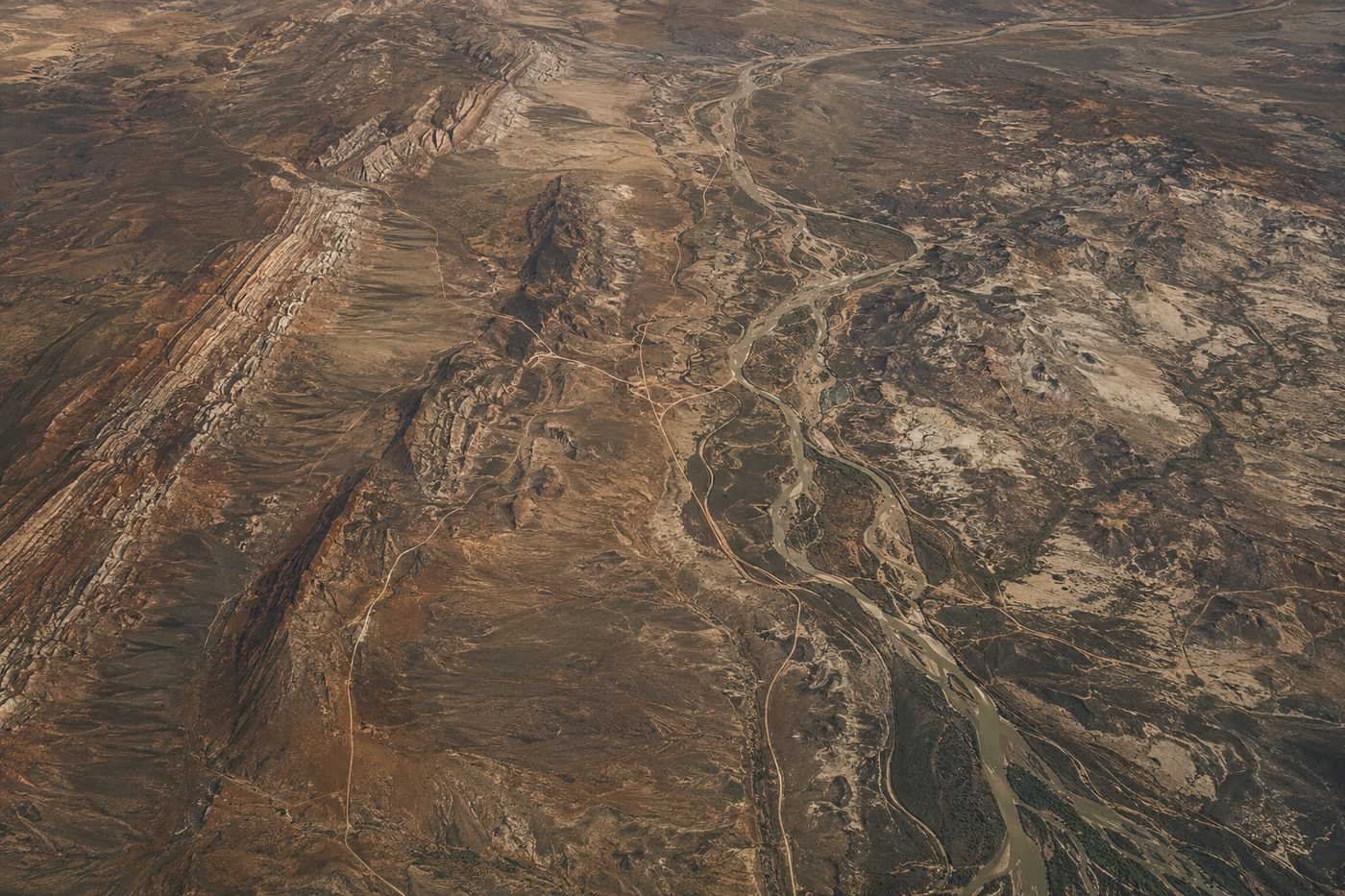 Aerial view of arid terrain showing vegetation patterns and drainage.